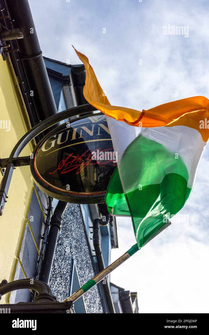 Bandiera nazionale tricolore irlandese e cartello Guinness fuori da un bar nella Contea di Donegal, Irlanda Foto Stock