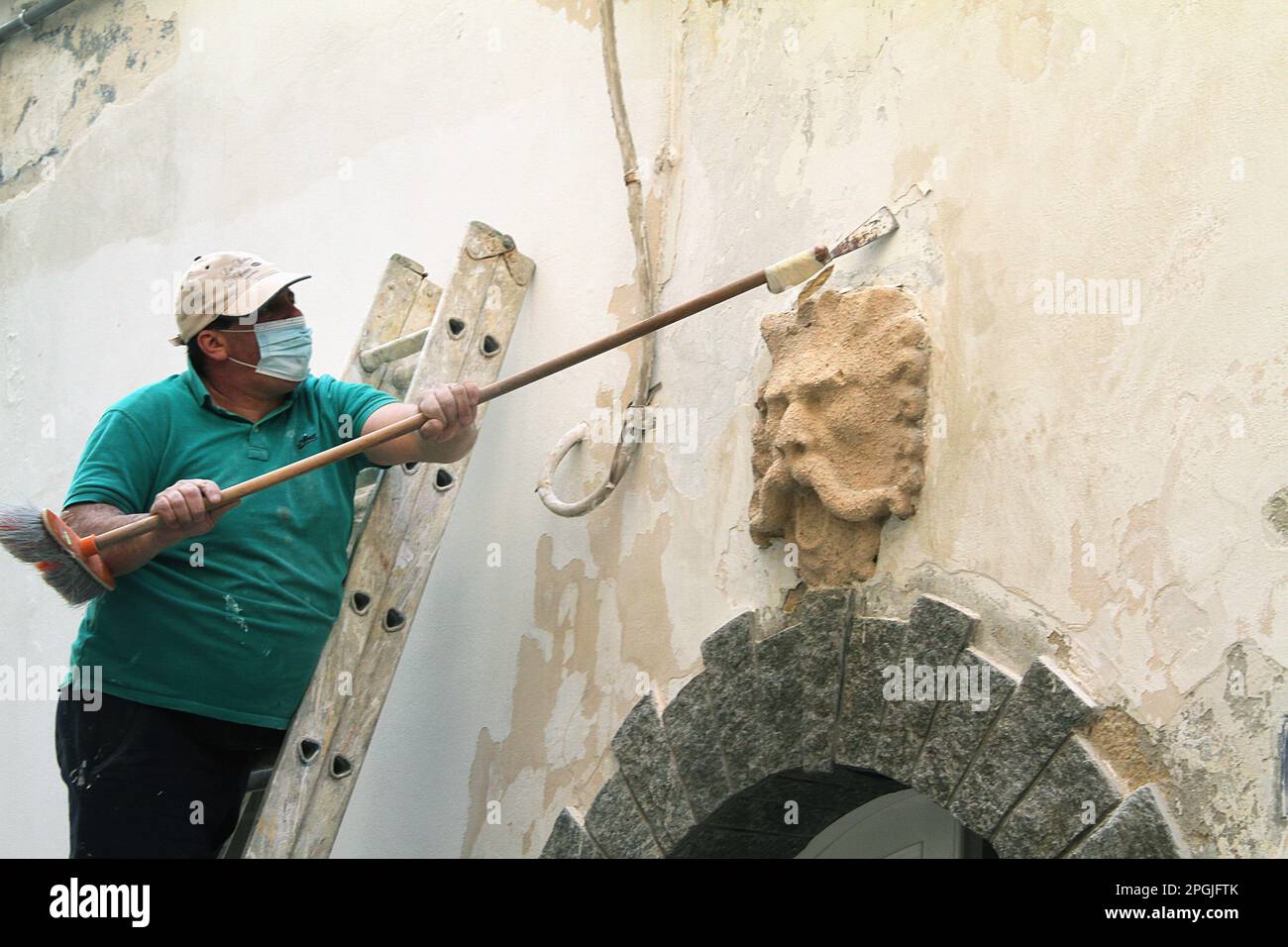 Gallipoli, Italia. Uomo che rinnova la facciata di un edificio nel centro storico. Foto Stock