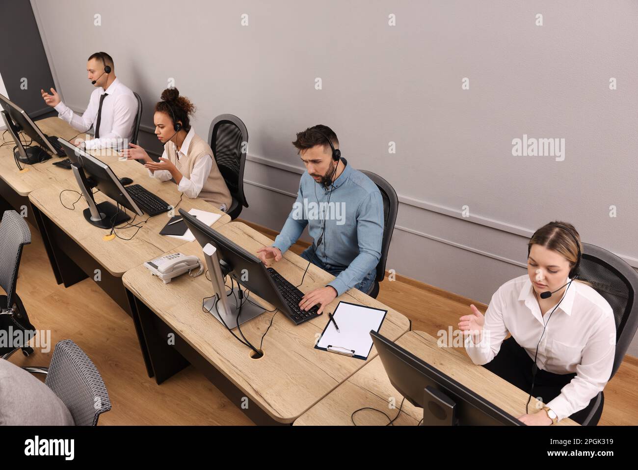 Operatori di contact centre che lavorano in uffici moderni, vista dall'alto Foto Stock