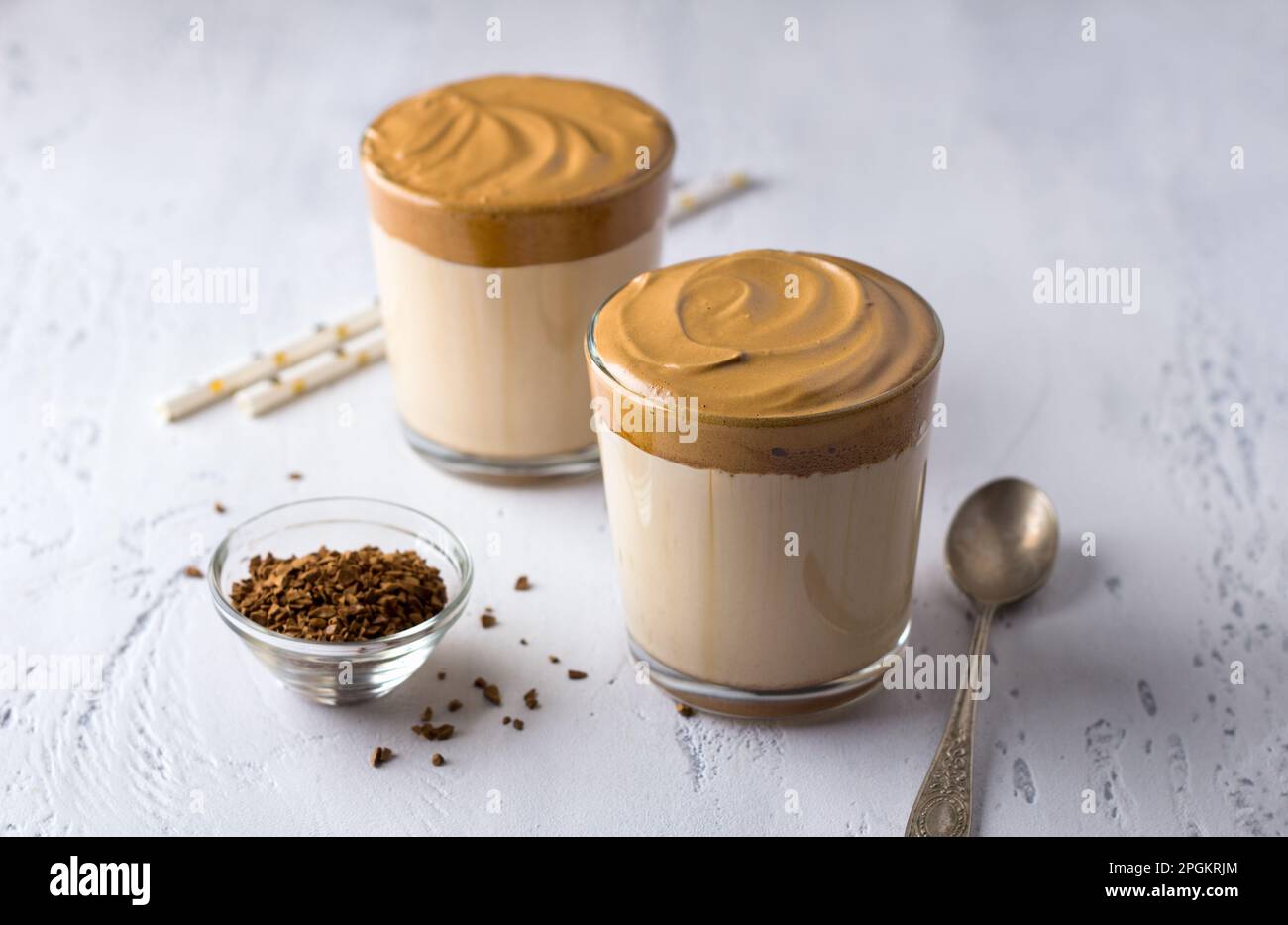 Due bicchieri con caffè Dalgona, cocktail freddo con schiuma di caffè montata, popolare bevanda di tendenza su sfondo chiaro Foto Stock