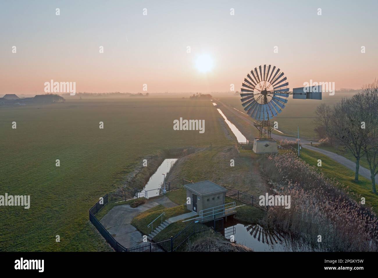 Aereo da un mulino a vento americano nella campagna da Friesland nei Paesi Bassi al tramonto Foto Stock