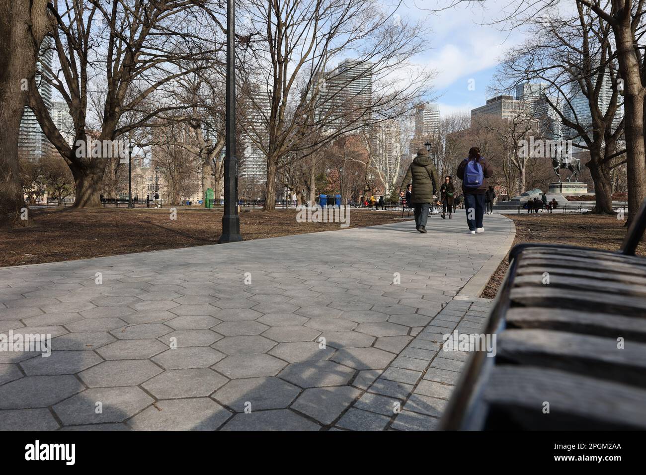 Persone che camminano attraverso un parco urbano. L'esercizio fisico può migliorare la salute mentale e il benessere. Spazio per testo o copia. Foto Stock