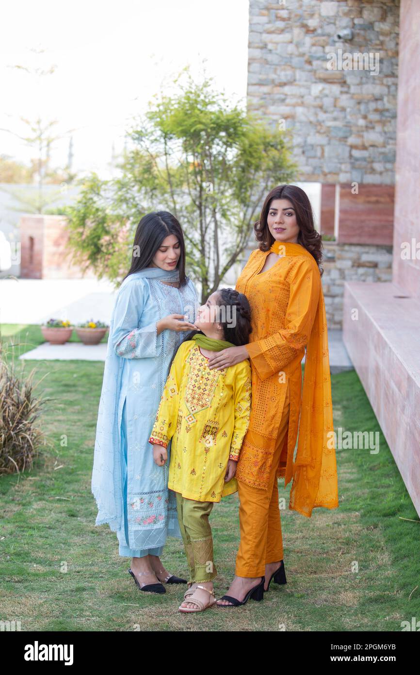 Modello femminile in posa all'aperto indossando arancione indiano pakistano asiatico tradizionale kameez salwar, Foto Stock