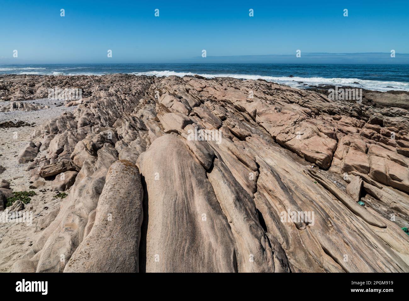 Tranquilla riva del mare atlantico in Sud Africa, Capo Settentrionale, con rocce in una giornata di sole con cielo blu. Foto Stock