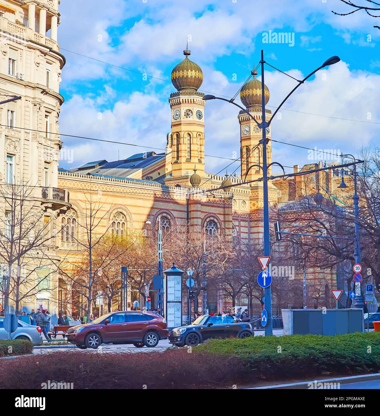 La scena stradale con ingorghi di traffico e la storica Sinagoga di Dohany Street con torri orribili e cupole bulbose, Belvaros, Budapest, Ungheria Foto Stock