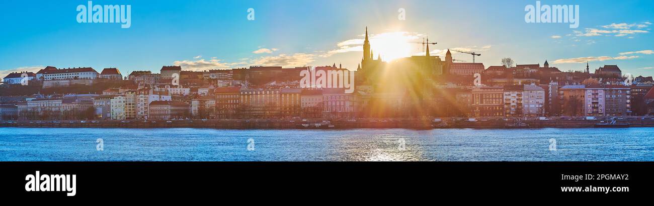 Panorama dell'azzurro Danubio e del quartiere di Buda sulla sua sponda opposta con sagome del Tempio di Marrhias e del Bastione dei pescatori contro il tramonto, Foto Stock