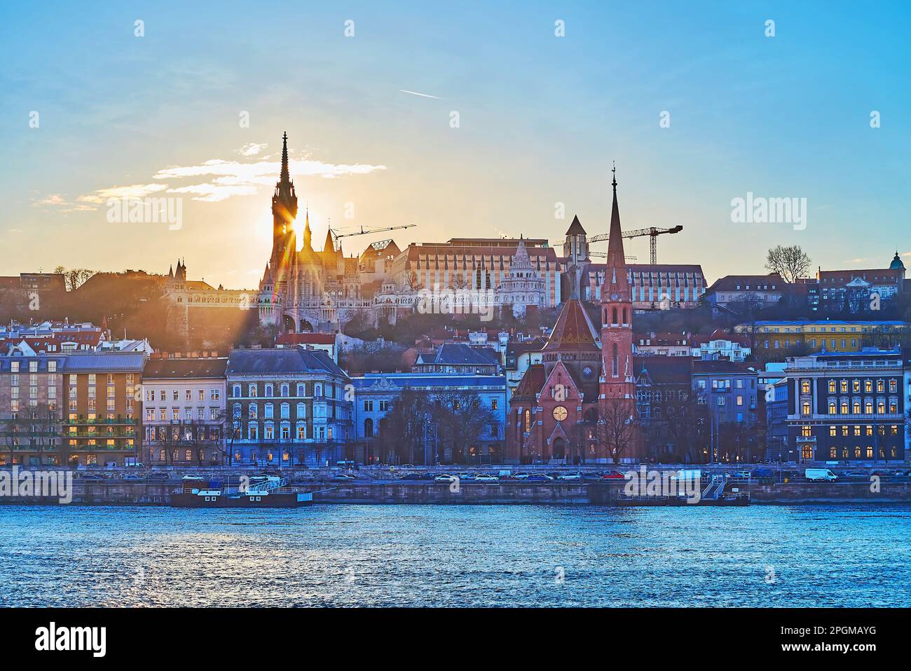 Silhouette del Bastione dei pescatori dietro il Danubio al tramonto dorato, Budapest, Ungheria Foto Stock