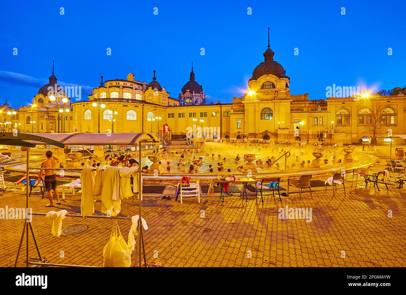 BUDAPEST, UNGHERIA - 22 FEBBRAIO 2022: Cortile illuminato con piscina termale esterna delle terme Szechenyi, il 22 febbraio a Budapest Foto Stock