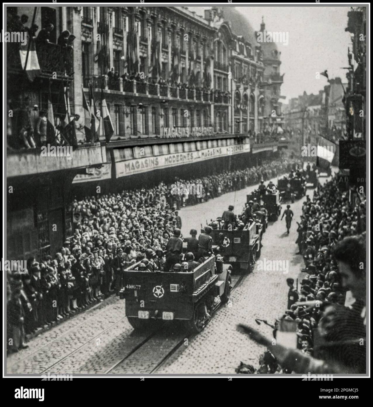WW2 Liberazione francese da parte delle forze americane in una città francese Francia 1944 folle francesi estatiche ondano verso i soldati americani GI nei loro veicoli carrier a mezza pista. Foto Stock