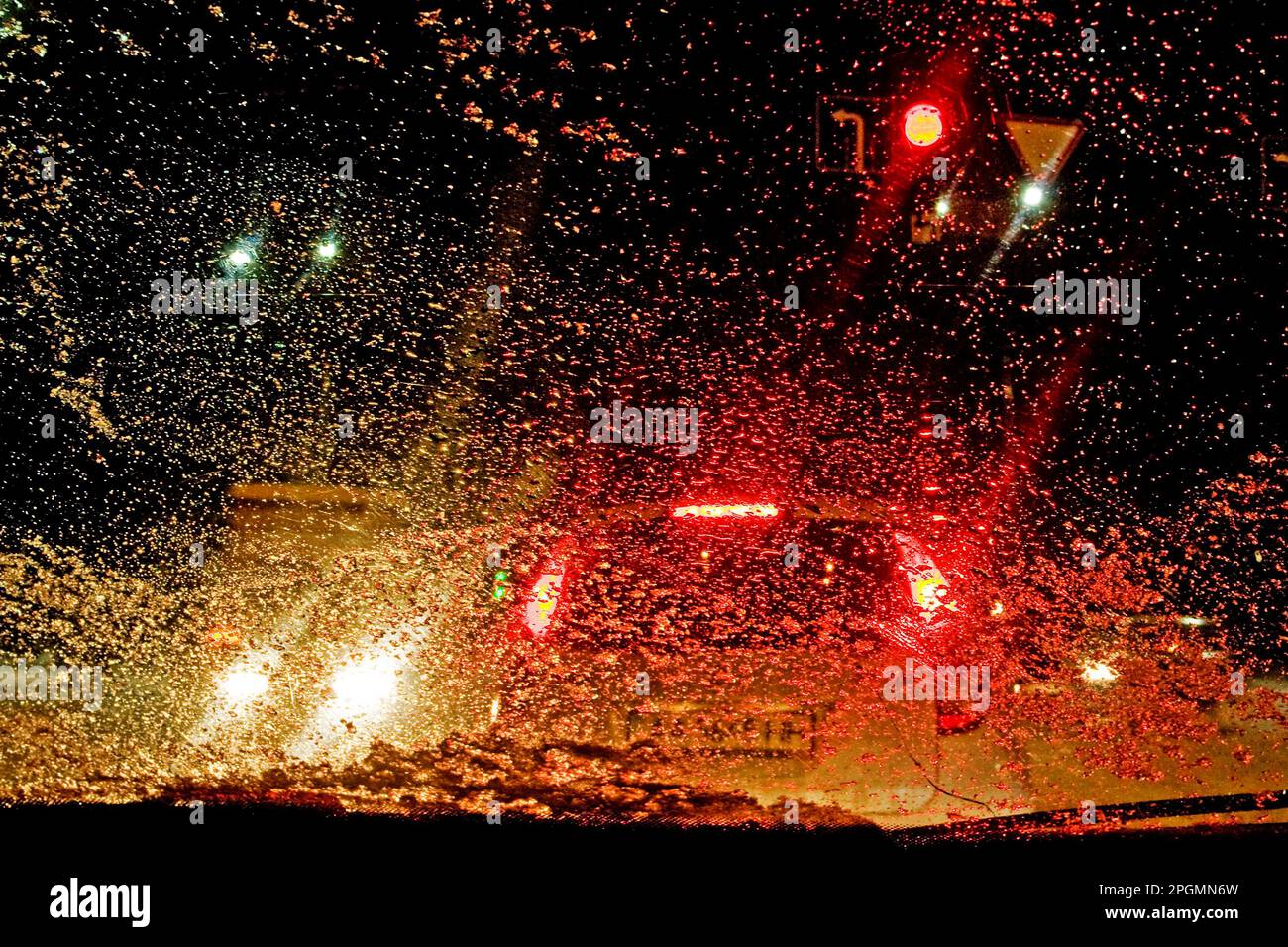 Fiocchi di neve, gocce d'acqua sul finestrino dell'automobile con lo sfondo di Bokeh alla notte nella città, fuoco selettivo Foto Stock