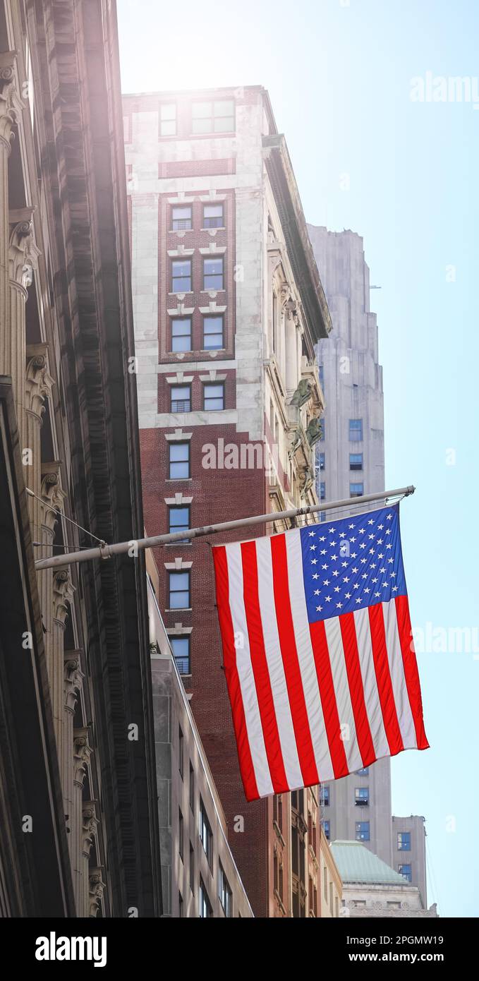 Bandiera americana con edifici sullo sfondo, fuoco selettivo, New York City, USA. Foto Stock