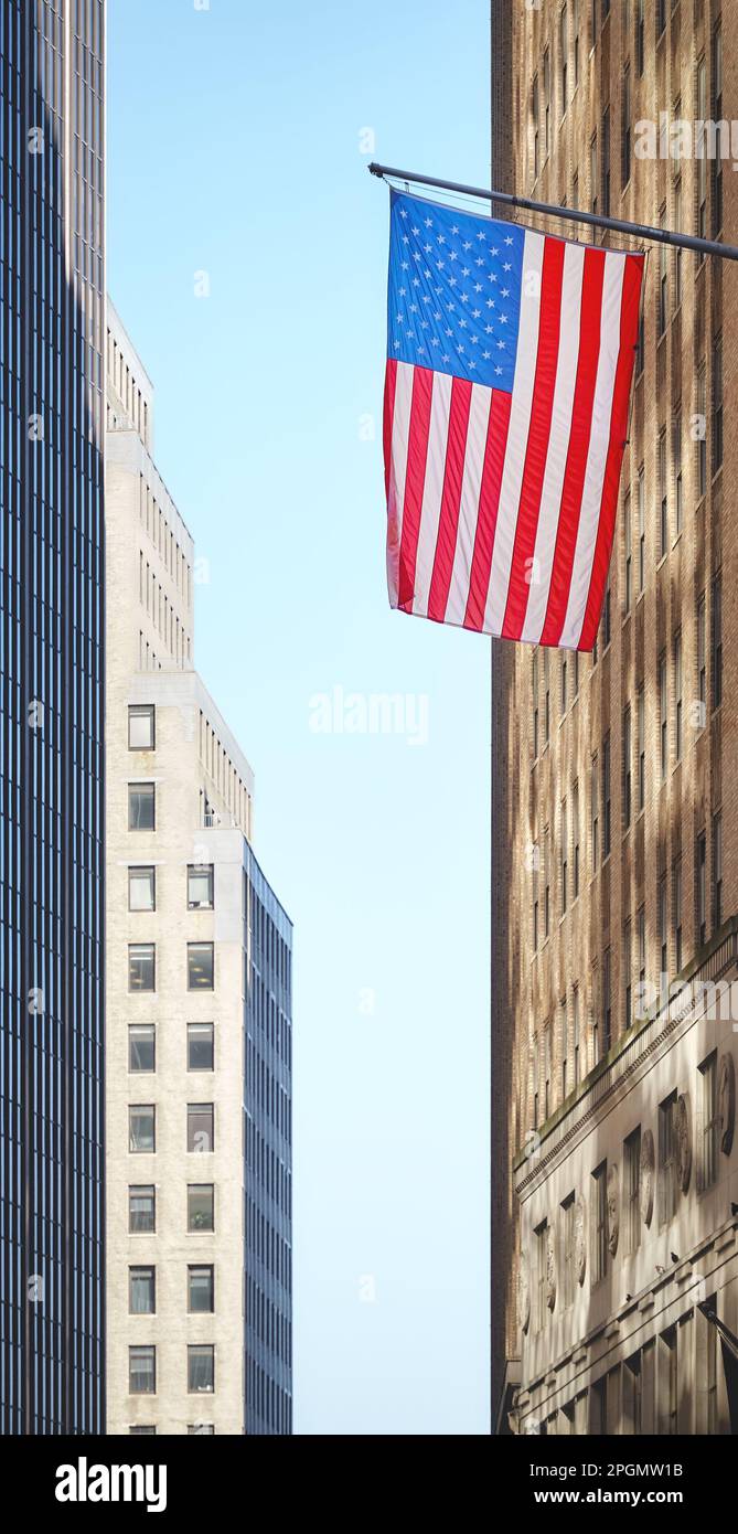 Bandiera americana con edifici sullo sfondo, fuoco selettivo, New York City, USA. Foto Stock