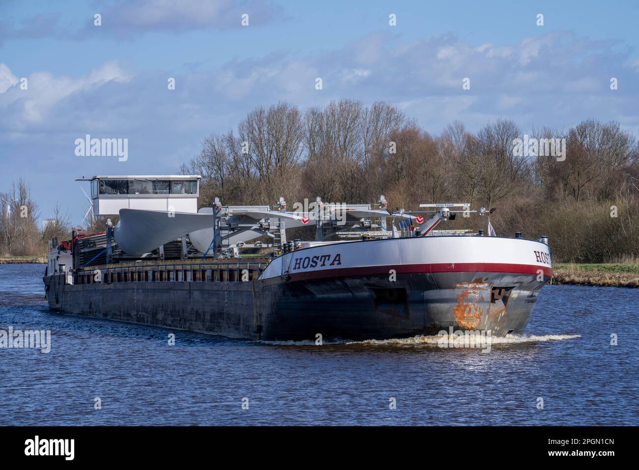 Trasporto di rotori, pale per turbine eoliche, da parte di un aereo da terra sui canali dei Paesi Bassi, vicino a Groningen, dal produttore all'assemblaggio in loco Foto Stock