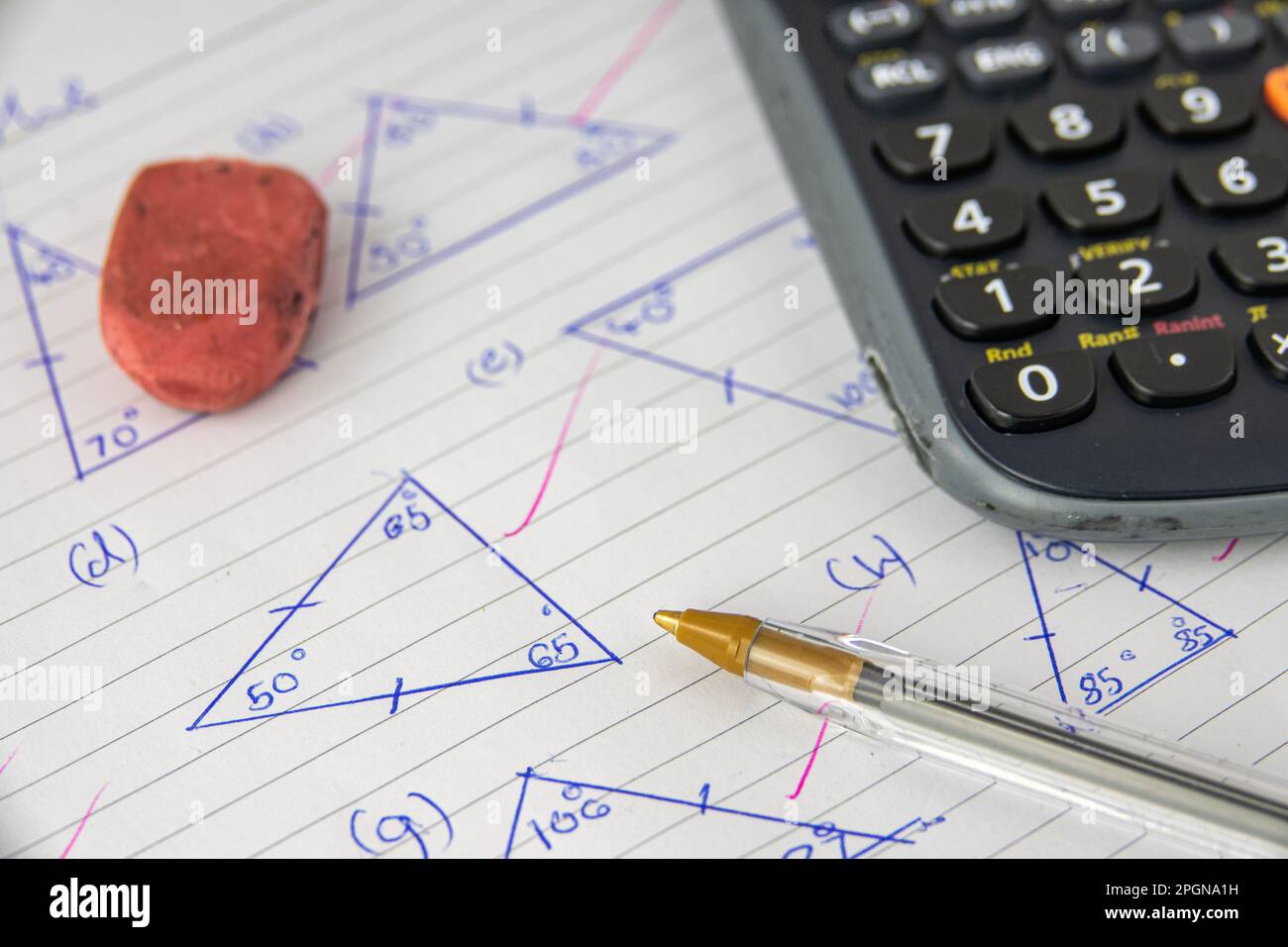 Un'esercitazione o un esame di matematica (geometria) del bambino, con calcolatrice, penna ed gomma Foto Stock