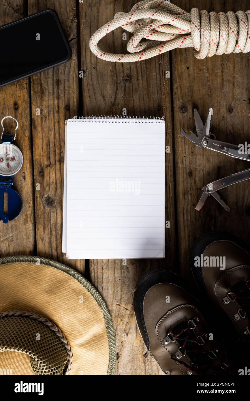 Attrezzatura da campeggio, smartphone e notebook bianco su sfondo di legno con spazio copia Foto Stock