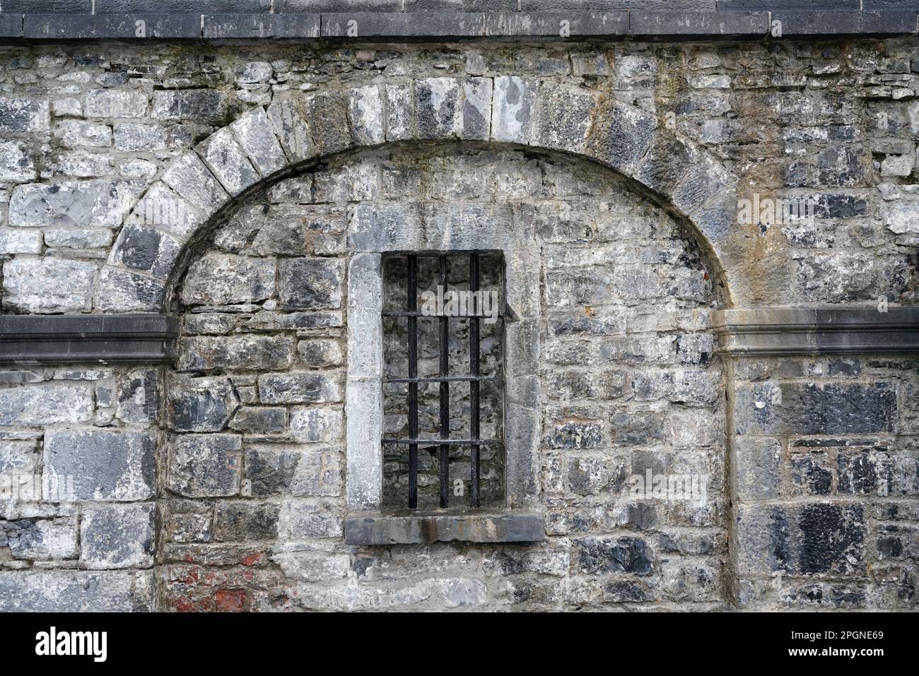bar della prigione sulla finestra in vecchio muro di pietra Foto Stock