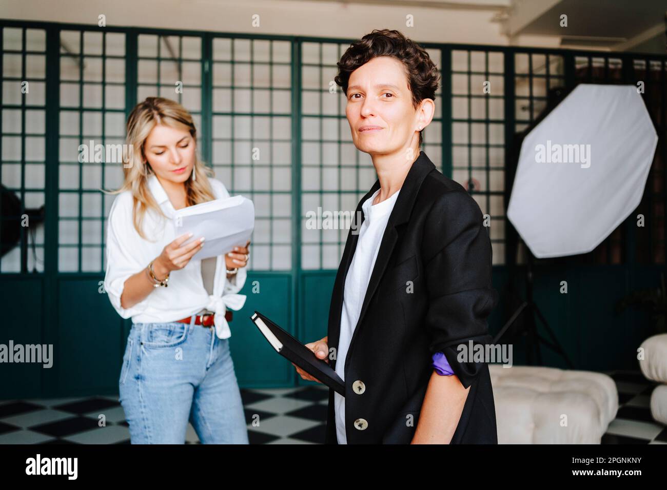 Regista sicuro in piedi con attrice sul set cinematografico Foto Stock