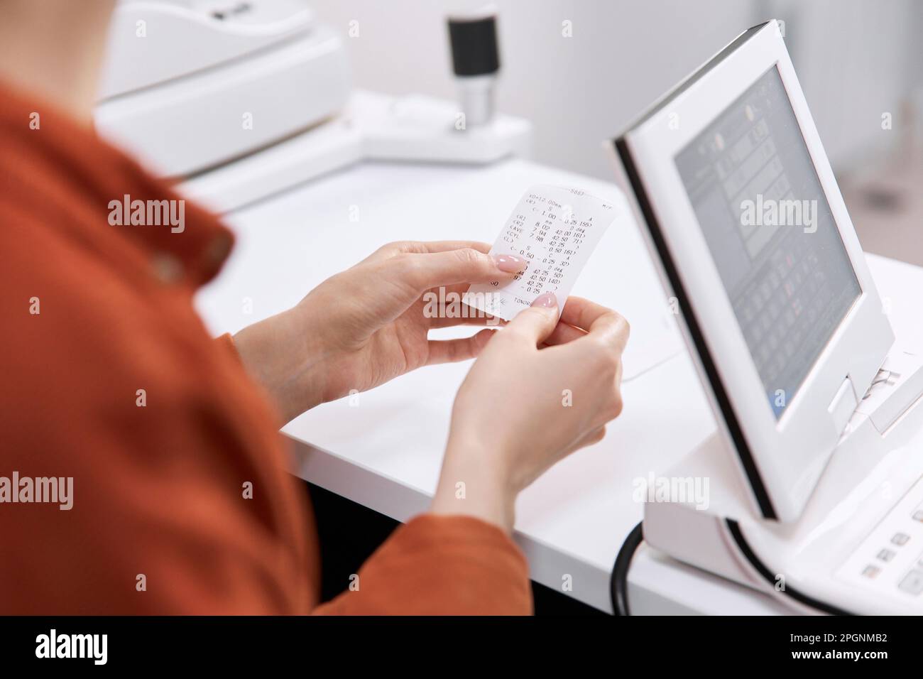 Le mani del paziente che tiene l'occhio controllano il risultato presso la clinica Foto Stock