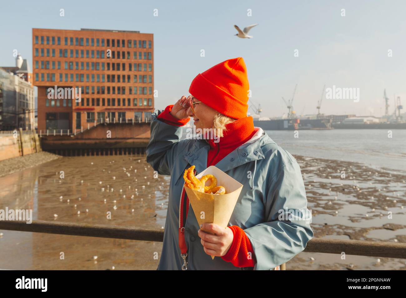 Donna che tiene pesci e patatine fritte Foto Stock