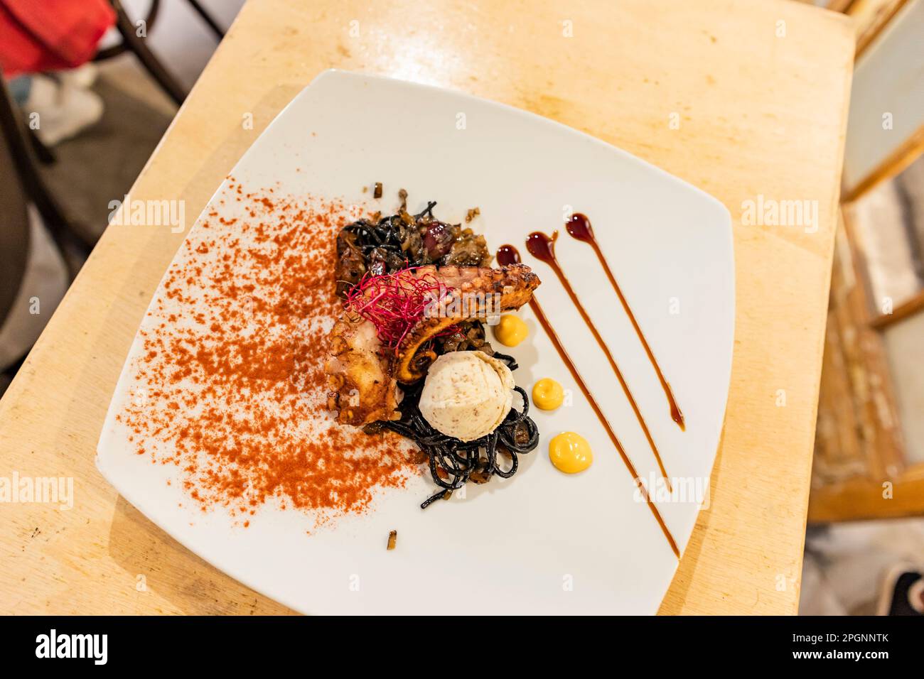 Polpo alla griglia con zafferano e seppia su piatto nel ristorante Foto Stock