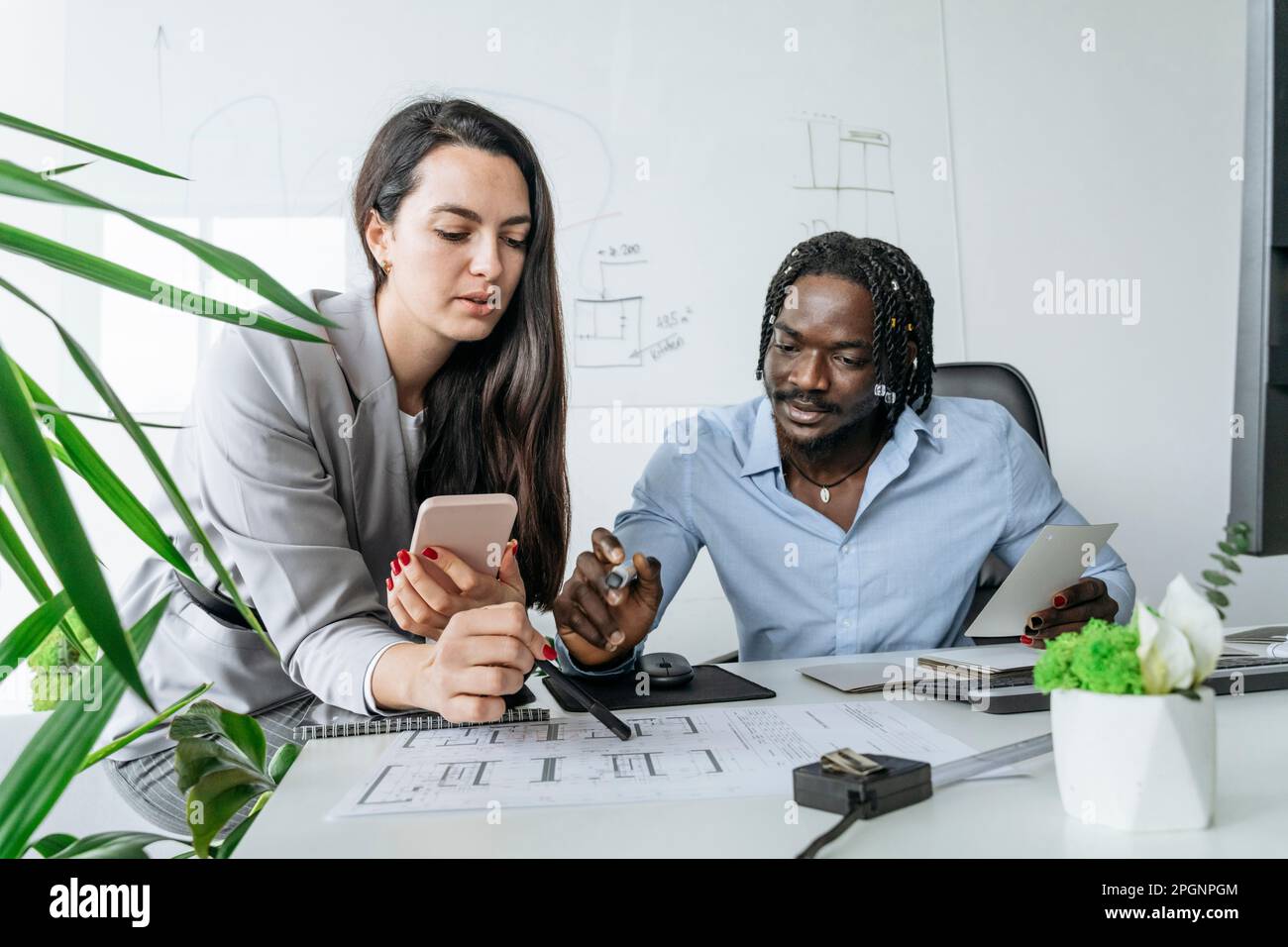 Architetto e collega che discutono di un progetto in ufficio Foto Stock