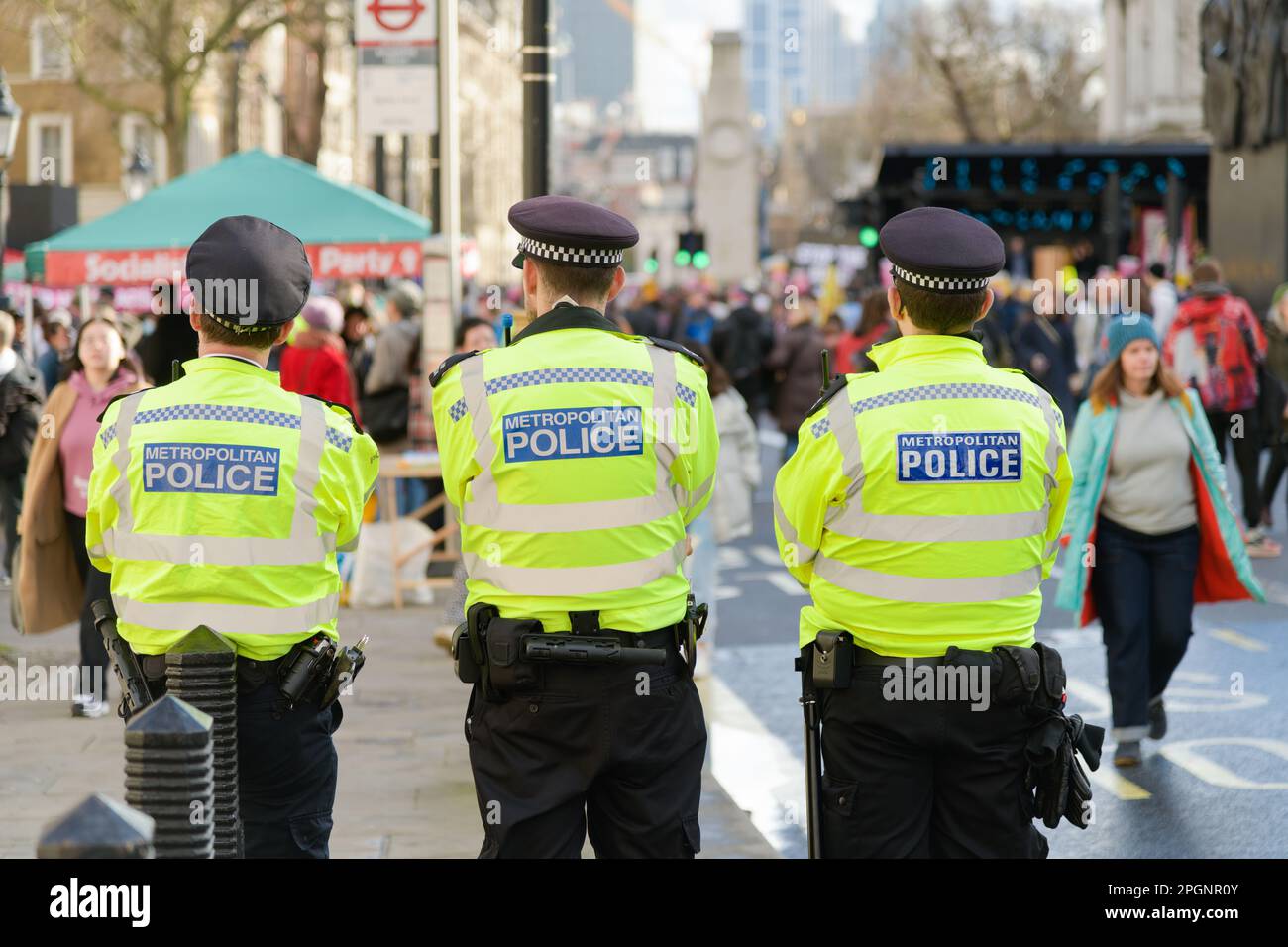 Londra, Regno Unito - Marzo 18 2023; tre membri della polizia metropolitana in uniformi ad alta visibilità guardano le proteste a Westminster Foto Stock