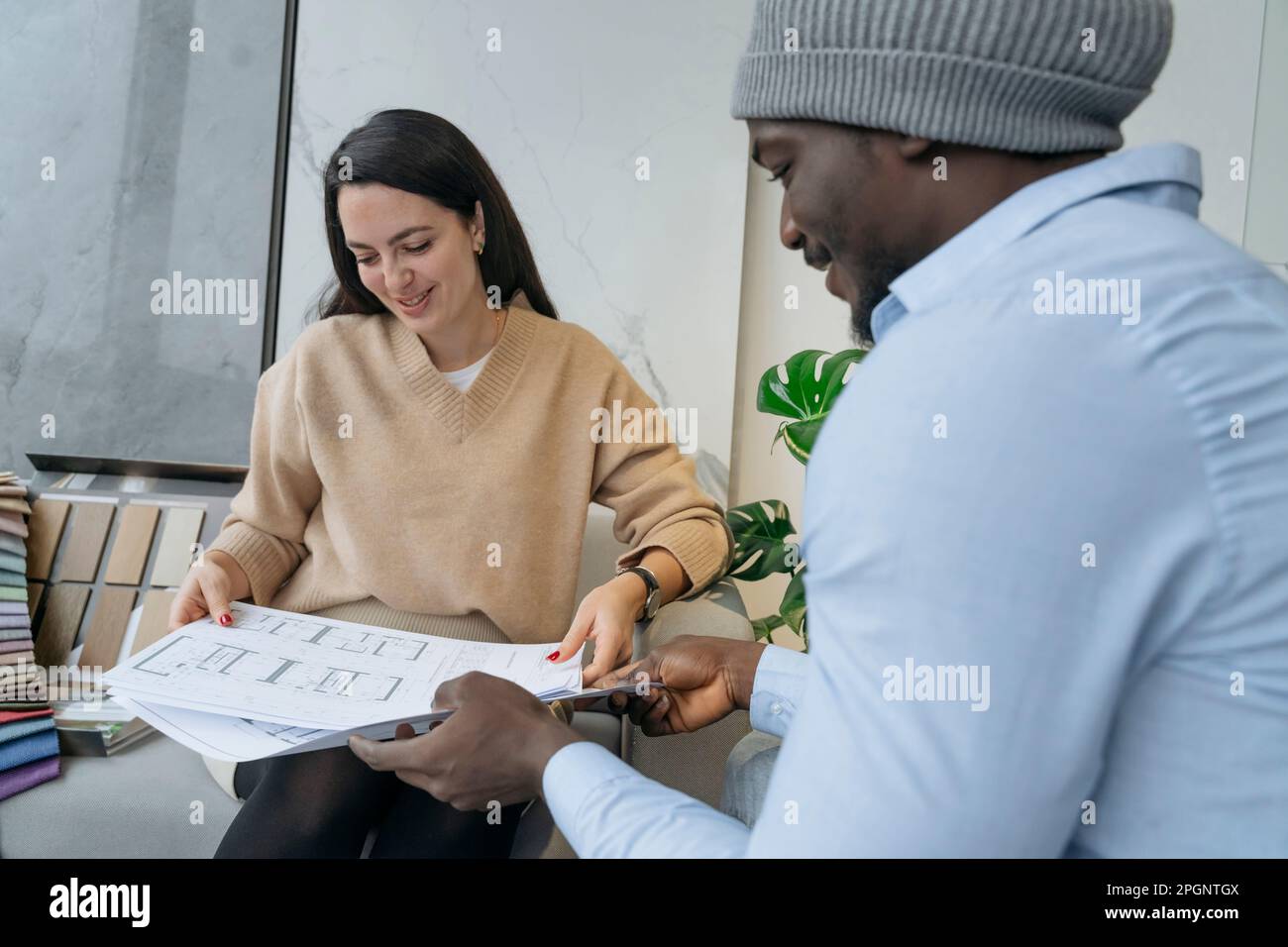 Donna d'affari sorridente che discute sopra i documenti con il collega in ufficio Foto Stock