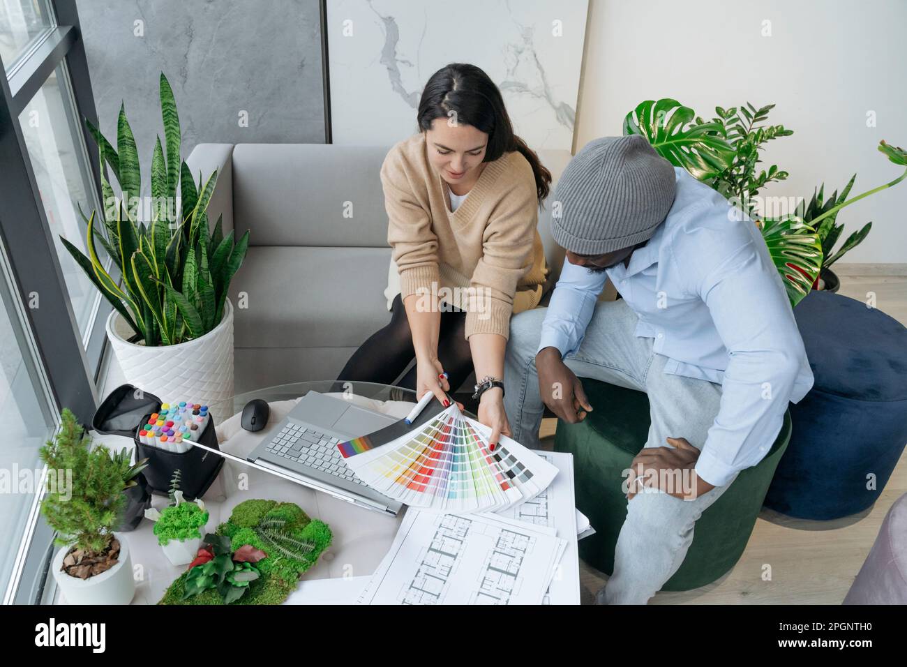 Architetto che discute con il collega sui campioni di colore sul posto di lavoro Foto Stock