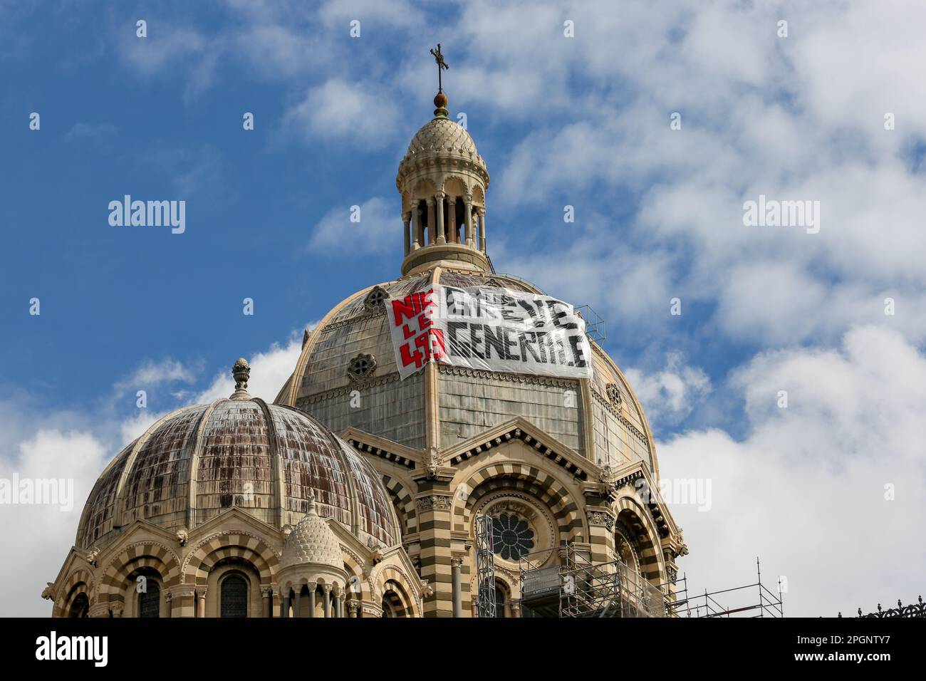 Marsiglia, Francia. 23rd Mar, 2023. Sulla cattedrale di Marsiglia, ai margini della manifestazione contro la riforma delle pensioni, è appeso uno striscione che chiede uno sciopero generale. I sindacati francesi hanno chiesto un 9th° giorno di azione contro la riforma pensionistica del governo francese che aumenterebbe l'età pensionabile da 62 a 64 anni. Il presidente francese Emmanuel Macron ha forzato la riforma delle pensioni utilizzando l'articolo 49,3 della Costituzione francese. L'articolo 49,3 consente al governo di forzare il passaggio di un disegno di legge senza un voto del parlamento (Foto di Denis Thaust/SOPA Images/Sipa USA) Credit: Sipa USA/Alamy Live News Foto Stock