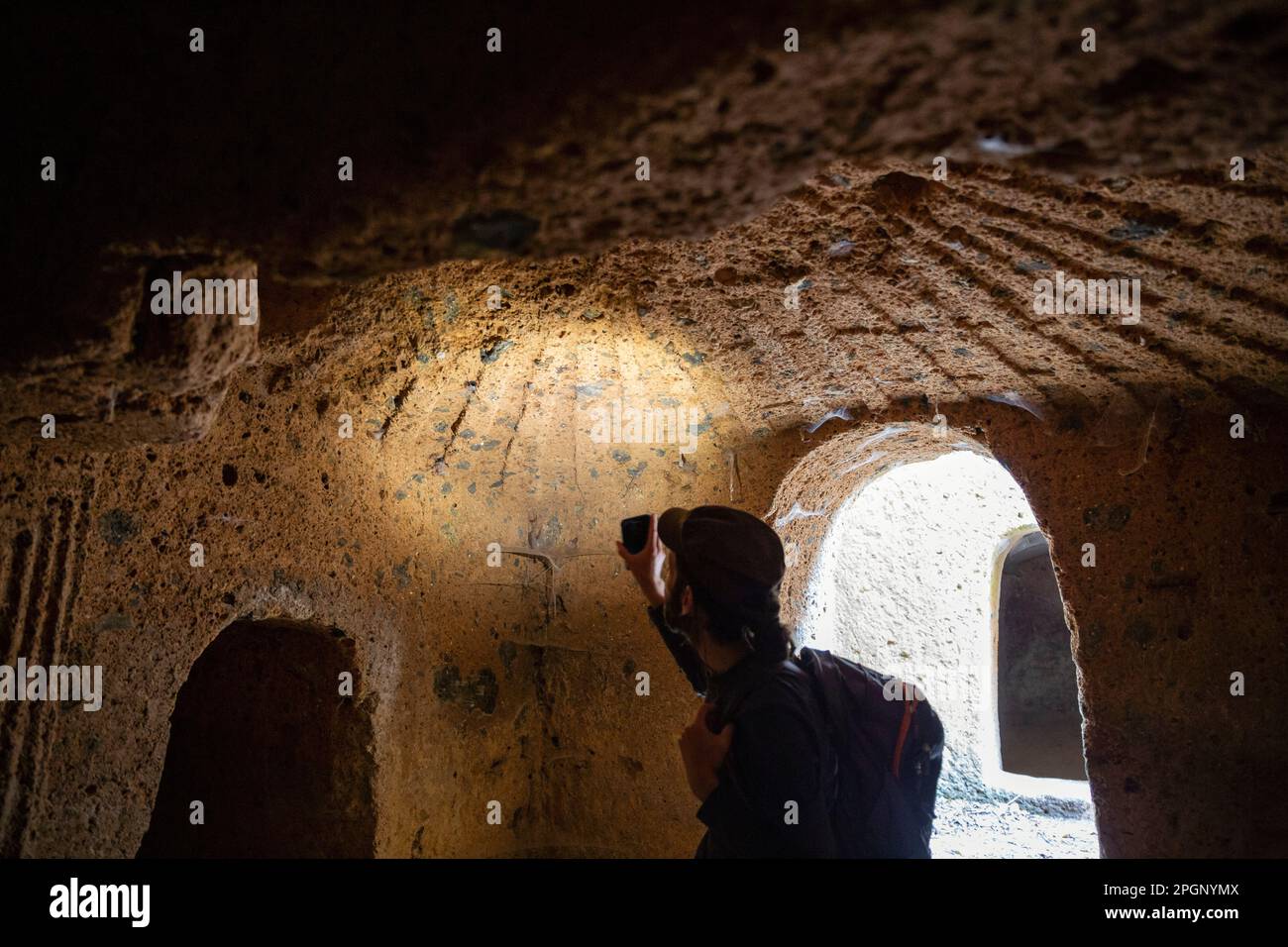 Visita turistica alla necropoli etrusca di San Guilano con torcia per smartphone Foto Stock