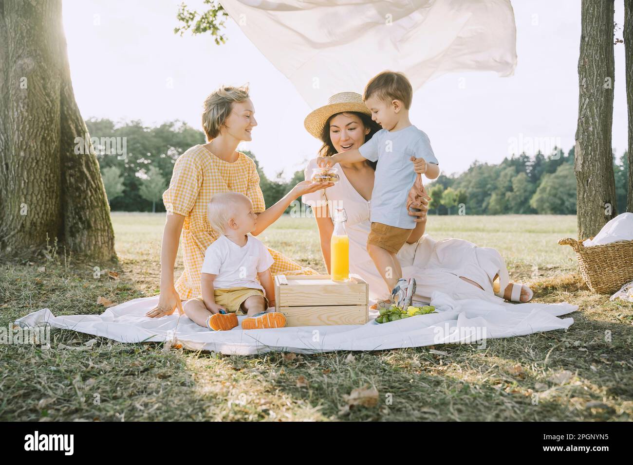 Buone donne che si divertano a fare un picnic con i figli nel parco Foto Stock