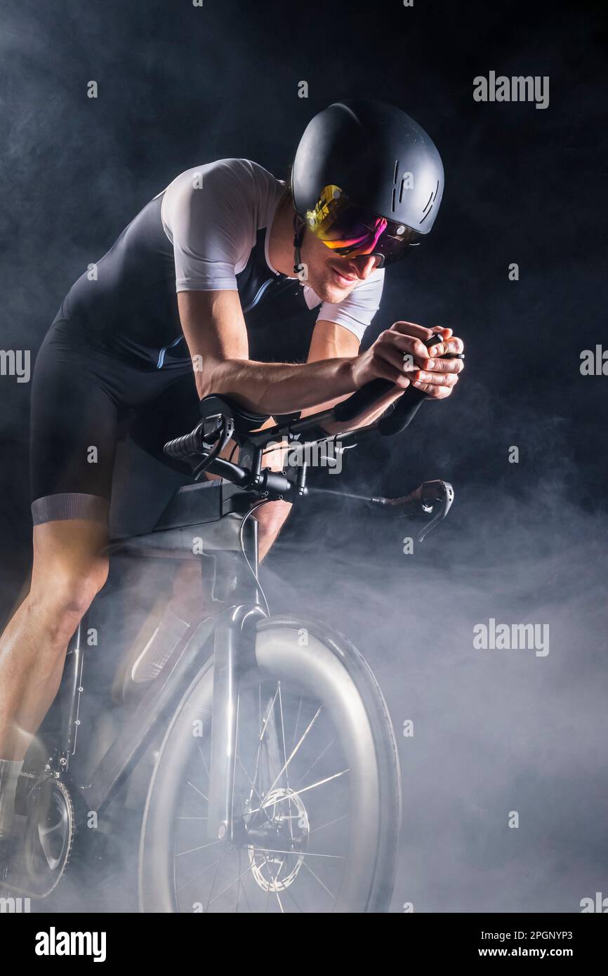 Ciclisti che praticano il ciclismo sul turbo trainer in mezzo al fumo Foto Stock