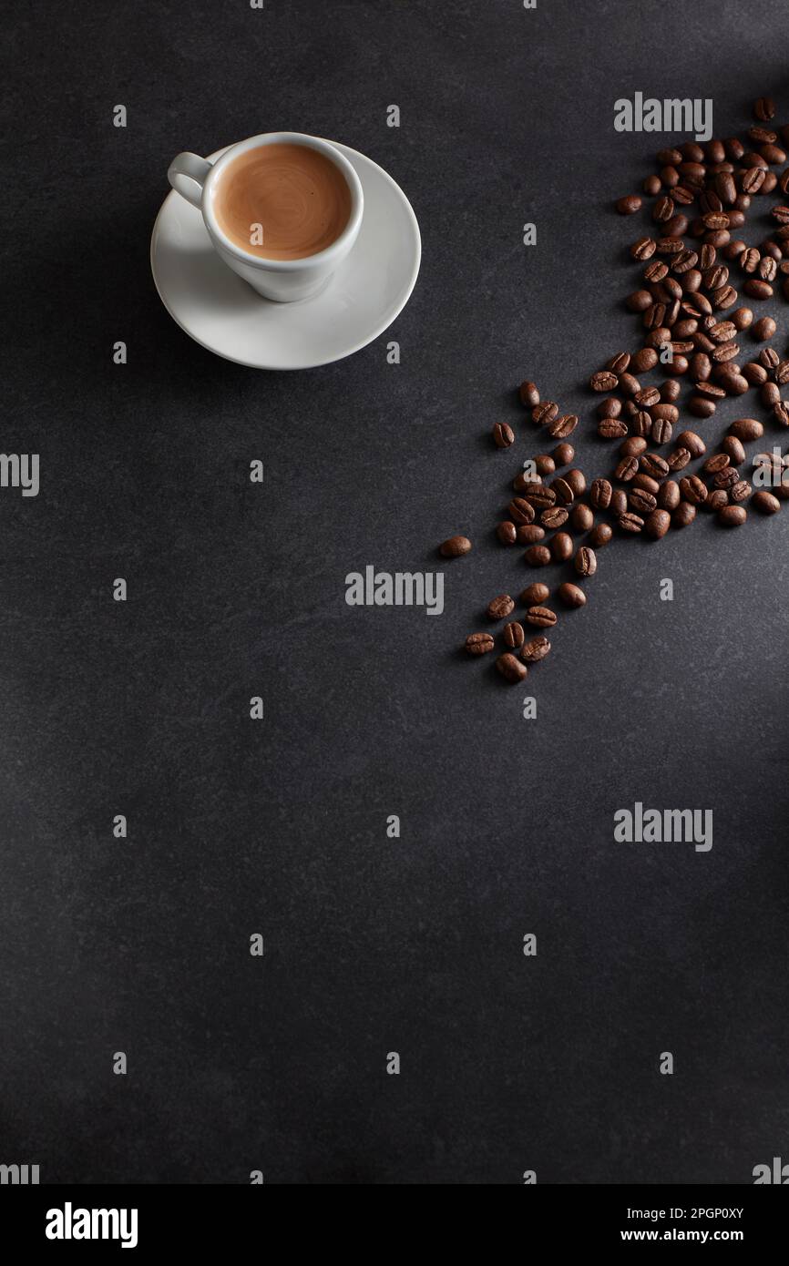 Tazza di caffè espresso e caffè tostato su sfondo nero Foto Stock