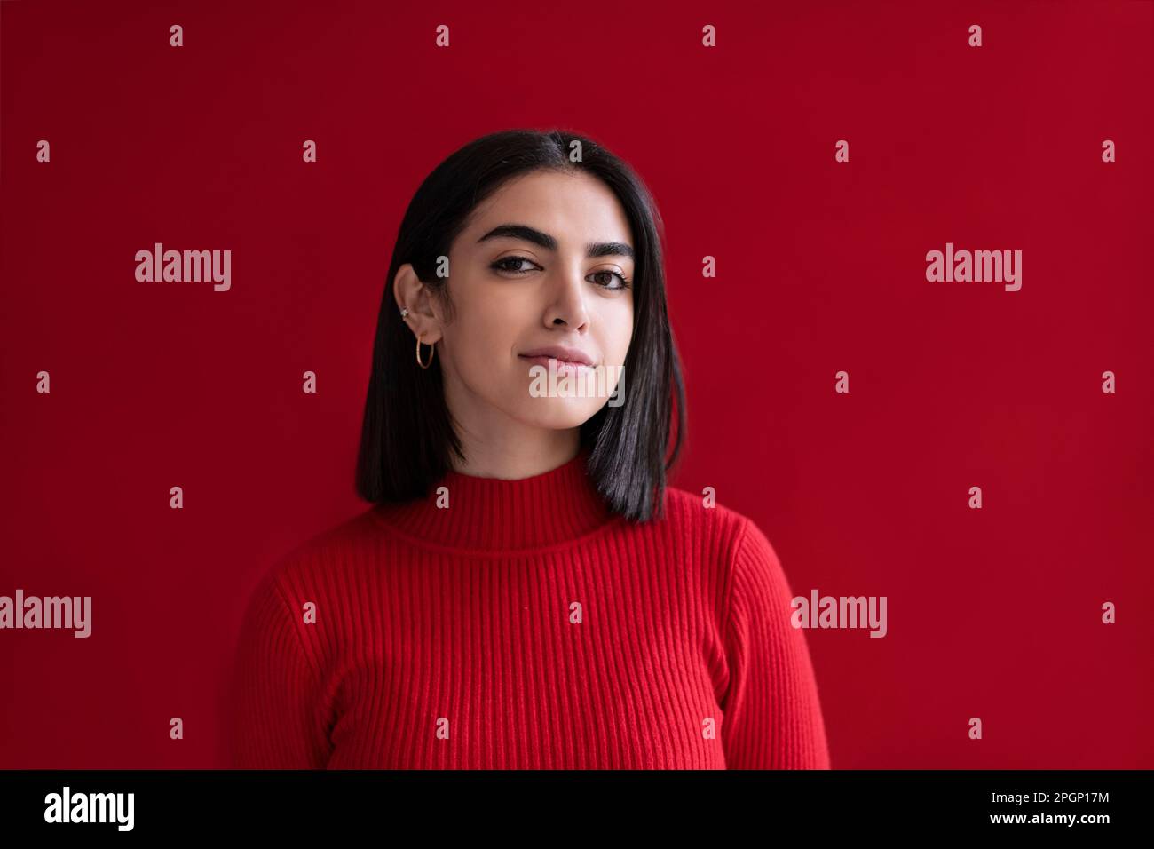 Giovane donna fiduciosa su sfondo rosso Foto Stock