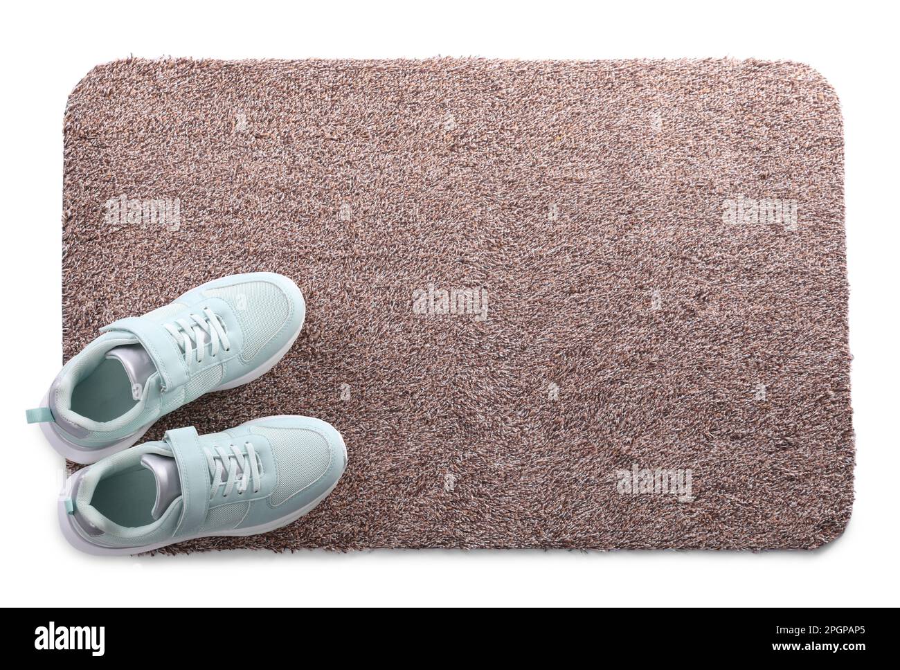 Elegante tappetino per porta con scarpe su sfondo bianco, vista dall'alto Foto Stock