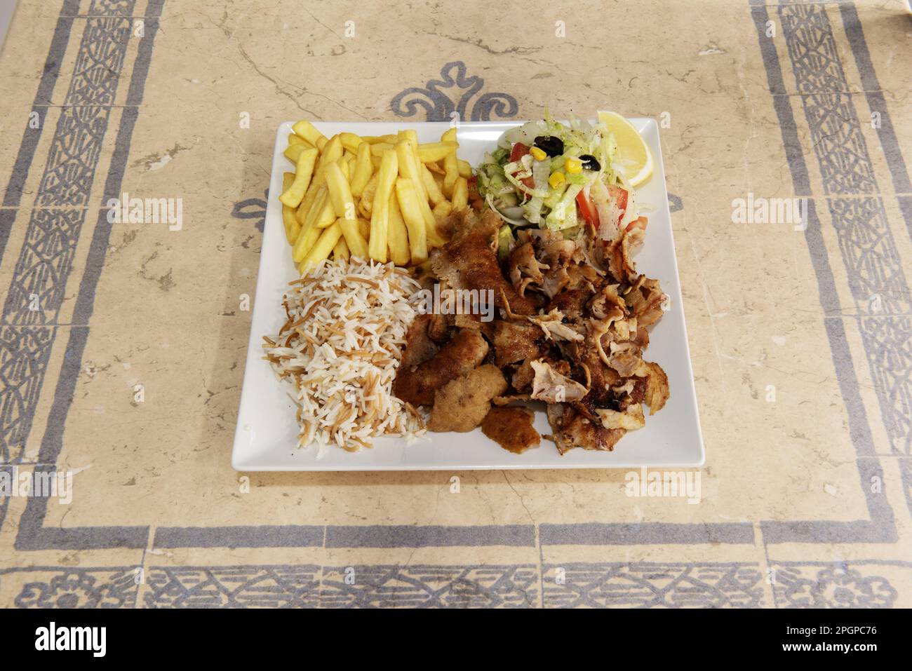 Il kebab è un piatto mediorientale composto da sottili fette di carne di agnello, pollo o manzo, di solito mangiato con un pane piatto come il pide o la pita lungo il wit Foto Stock