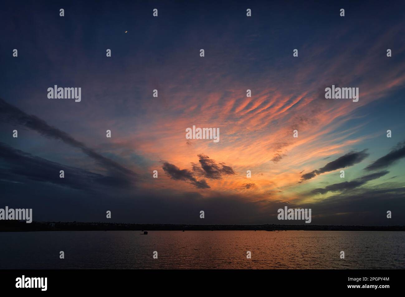 Un tranquillo Lago Blu con uno splendido cielo colorato Foto Stock