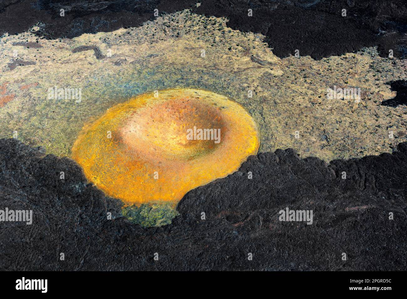 Vista aerea di un cratere vulcanico collassato con lava solidificata che crea intricate texture e forme. Foto Stock