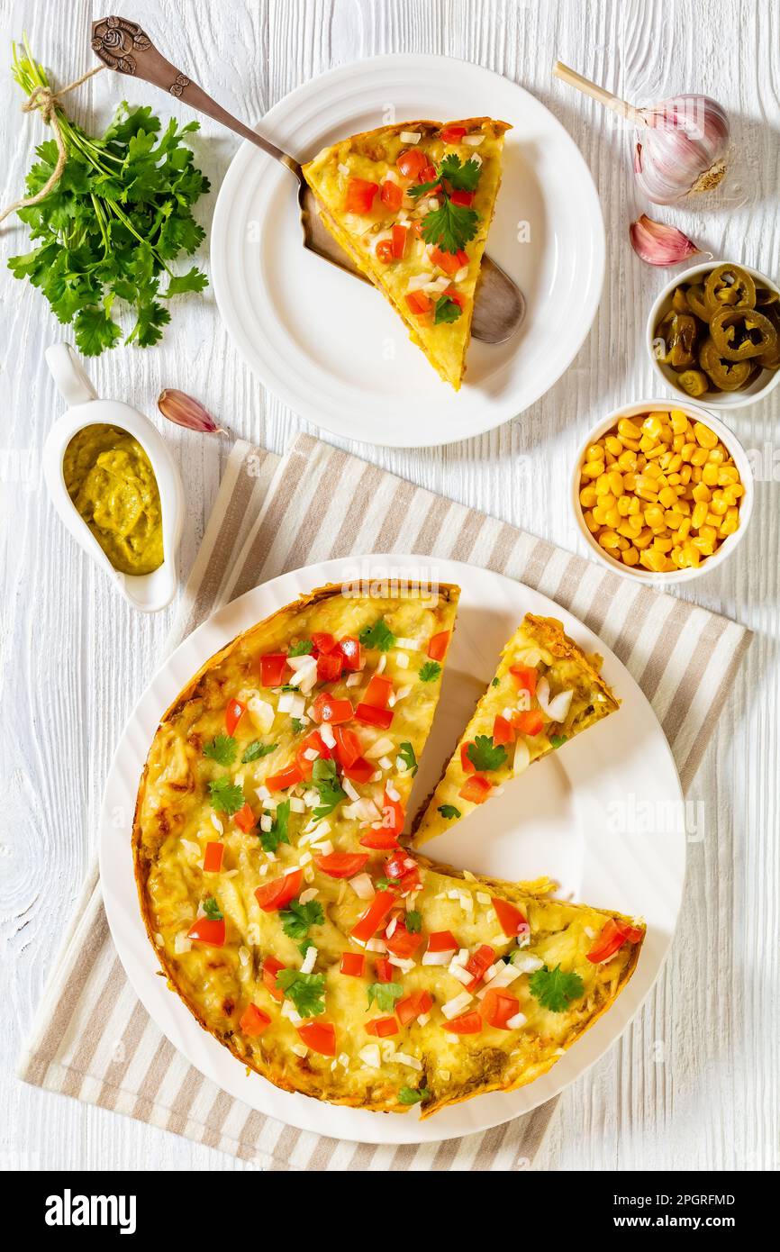 Enchilada vegetariana Verde Cile Casserole di tortillas di mais stratificato con fagioli, corni, salsa e formaggio, sormontato da pico de gallo, verticale Foto Stock