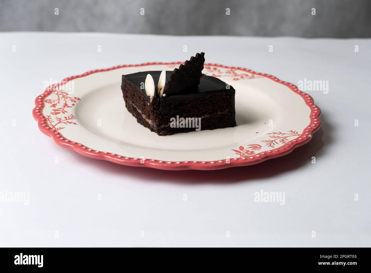 Piatto con fetta di gustosa torta al cioccolato fatta in casa sul tavolo Foto Stock
