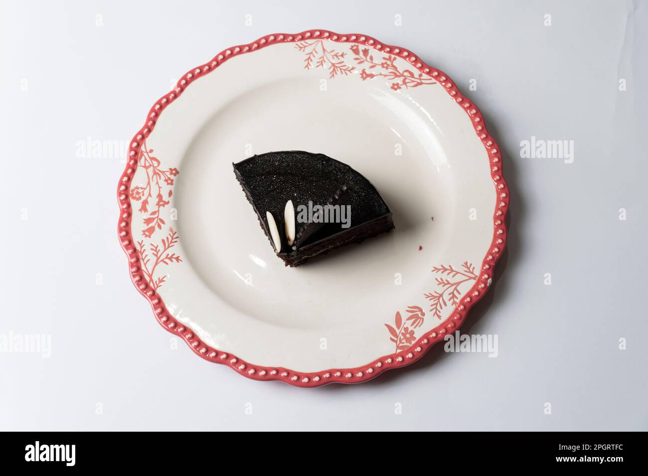 Piatto con fetta di gustosa torta al cioccolato fatta in casa sul tavolo Foto Stock