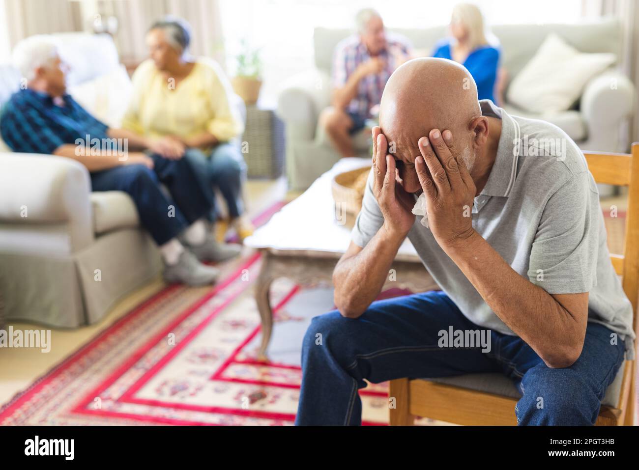 Gruppo di amici anziani emozionali e diversi in soggiorno durante la sessione di terapia di gruppo. Stile di vita, amicizia e supporto senior. Foto Stock