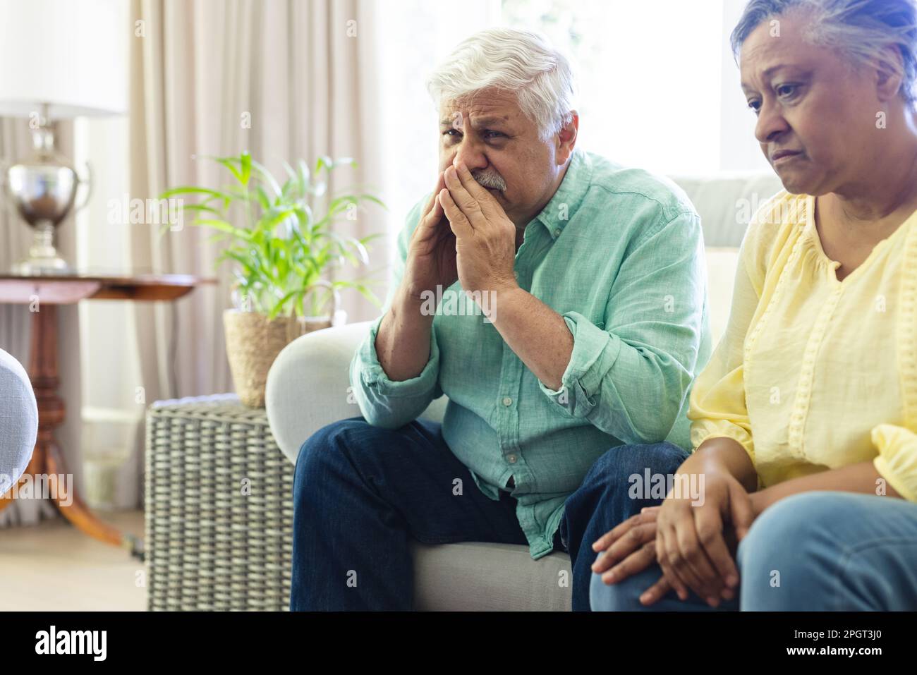 Triste gruppo di amici anziani diversi seduti in salotto, ascoltando durante la sessione di terapia di gruppo. Stile di vita, amicizia e supporto senior. Foto Stock