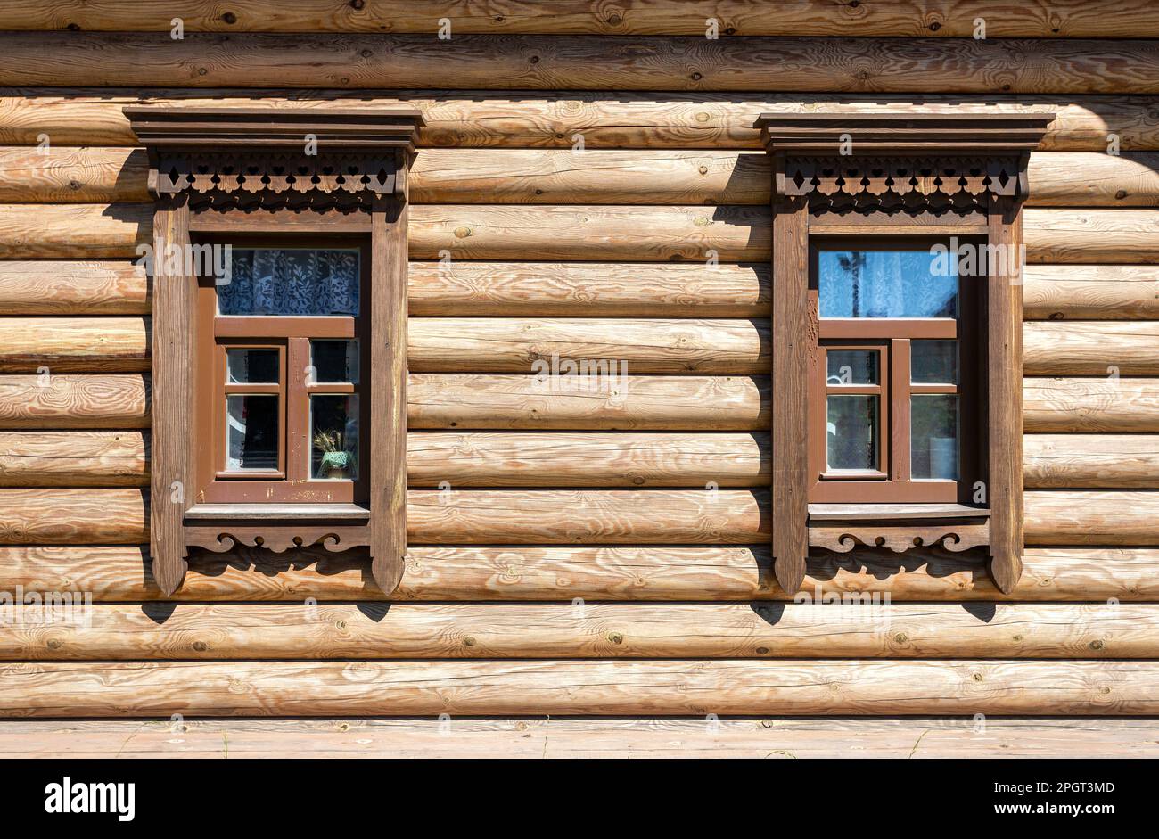 Tradizionale architettura russa in legno. Finestre di casa in legno decorate con intagli in legno, platbands, ornamento in pizzo in legno Foto Stock