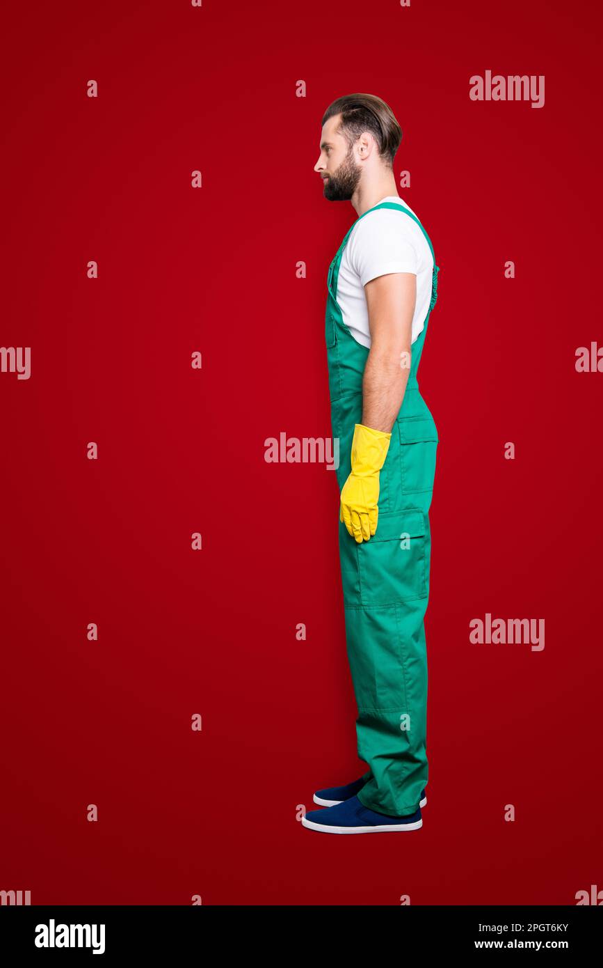 Vista laterale mezzo viso snap, full size ritratto di virile aspro barbuto concentrato uomo con barba corta, acconciatura in uniforme verde, isolato su Foto Stock