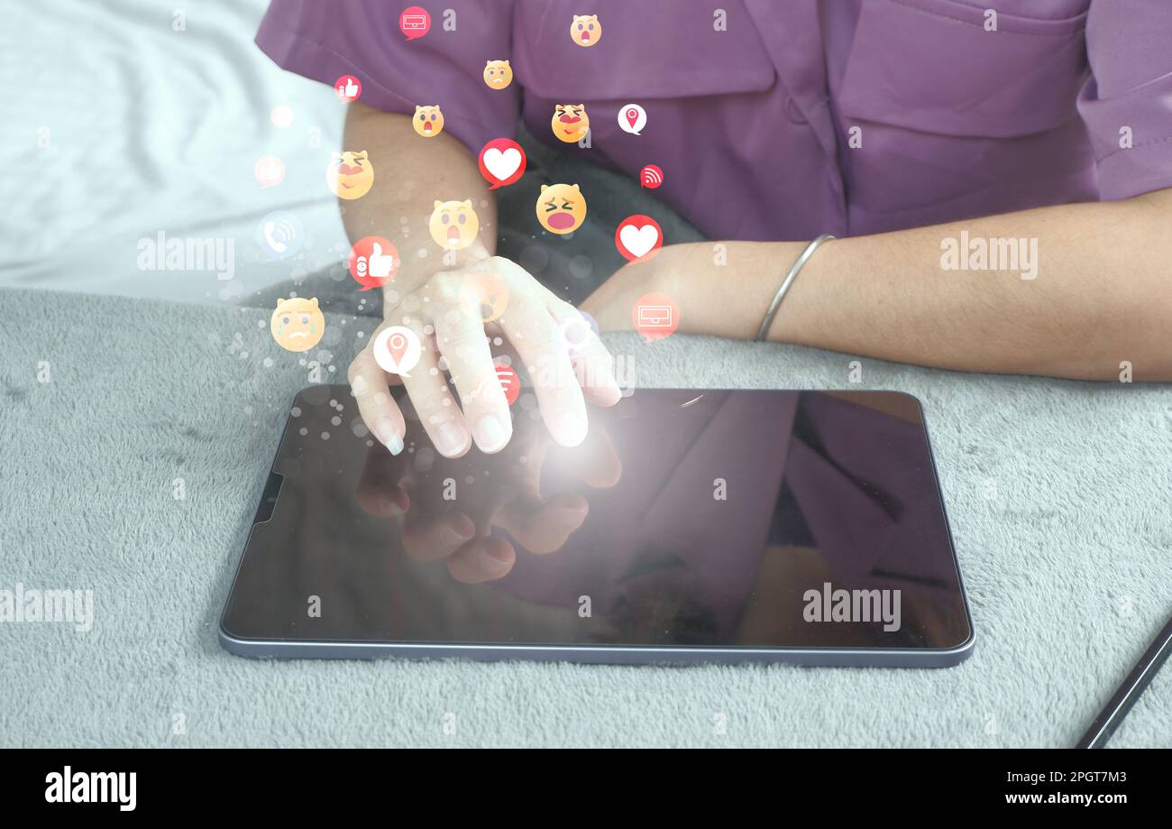 Social media e concetti digitali online che escono come un'icona ologramma: Concetto di vita in vacanza e social media distensione, lavorando da casa. Foto Stock