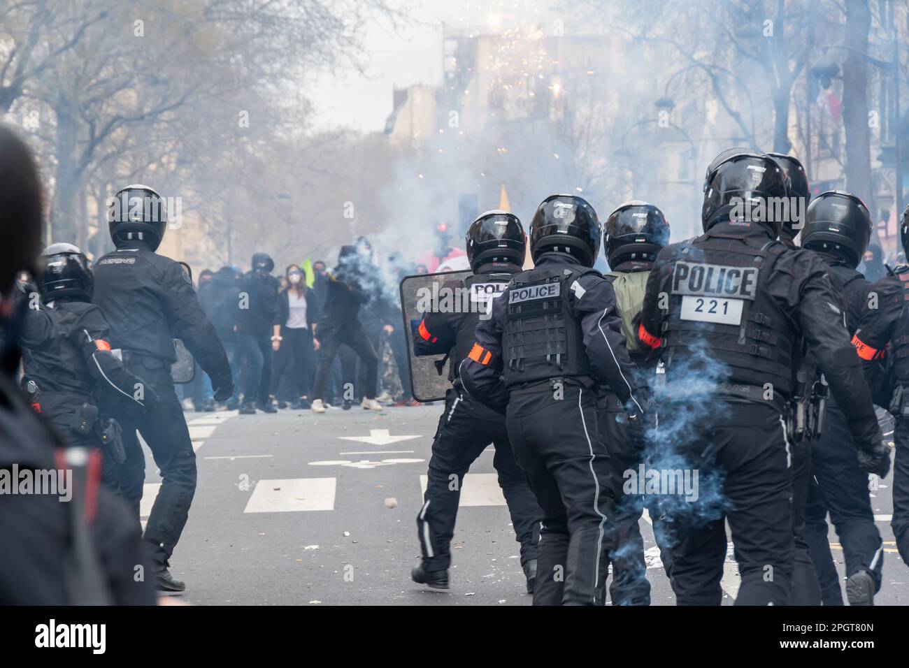 La polizia antisommossa francese ( Brav ) si trova a fronteggiare i disonori nel fumo di gas lacrimogeni alla fine di una protesta contro la riforma pensionistica in una strada di Parigi, Francia Foto Stock