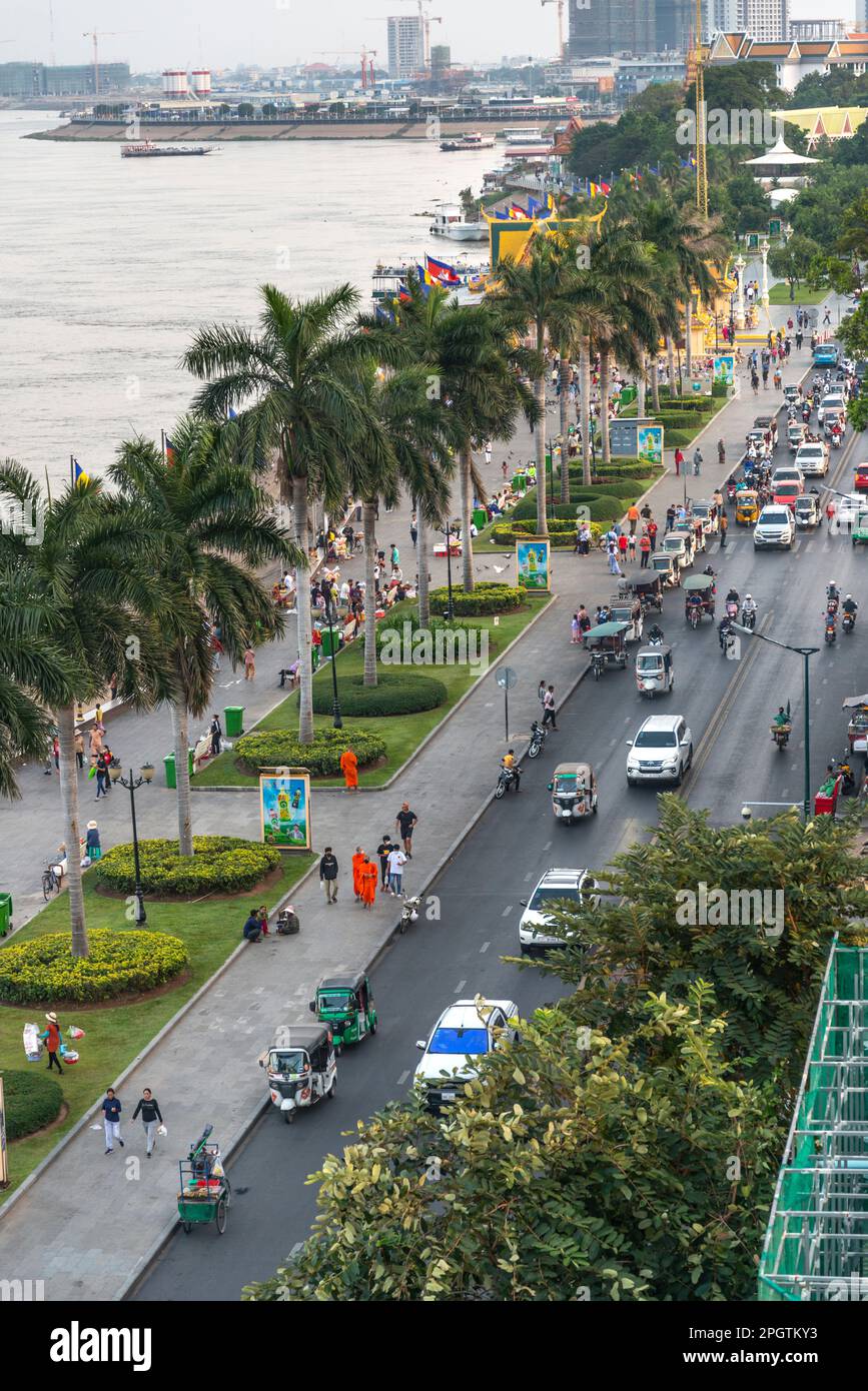Molte automobili cambogiane, moto e Khmer persone al tramonto, l'ora più trafficata del day.Sisowath Quay, una striscia popolare e zona pedonale, persone e famiglie co Foto Stock