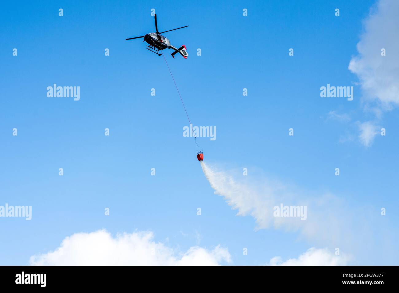 Bad Zwischenahn, Germania. 24th Mar, 2023. Un elicottero Eurocopter EC 135 T2i appartenente alla polizia della Sassonia sorvola un campo aereo con un serbatoio d'acqua antincendio, il cosiddetto Bambi Bucket. Gli squadroni di elicotteri della polizia della bassa Sassonia, Sassonia e Baviera stanno provando per le emergenze in due giorni nel distretto di Ammerland della bassa Sassonia. Circa 60 poliziotti e vigili del fuoco si eserciteranno nella lotta contro gli incendi boschivi e boschivi dall'aria fino al 25 marzo 2023. Credit: Hauke-Christian Dittrich/dpa/Alamy Live News Foto Stock