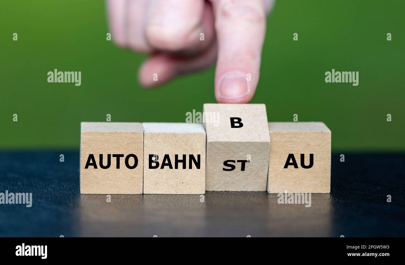 La mano gira a cubo e cambia l'espressione tedesca 'Autobahnstau' (ingorgo sulla superstrada) in 'Autobahnbau' (costruzione della superstrada). Foto Stock